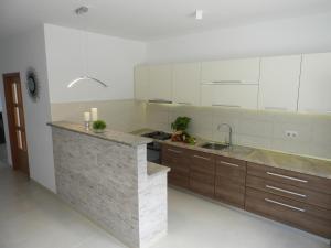 a kitchen with white cabinets and a counter with a sink at House Pierro in Orasac