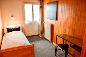 a bedroom with a bed and a desk and a window at First Lodge in Grindelwald