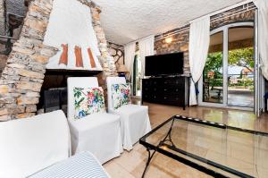 salon z 2 białymi krzesłami i kominkiem w obiekcie Vila RA w Rovinj