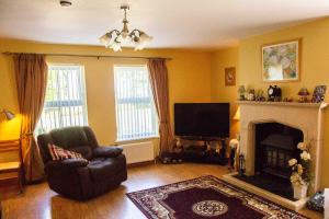 a living room with a chair and a fireplace at Groarty House/Manor in Derry Londonderry