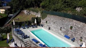 vista sul soffitto di una piscina accanto a un muro di pietra di Hotel San Marino a Laglio