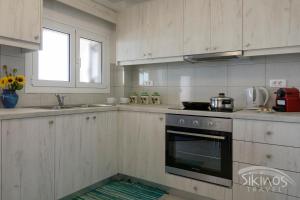 una cocina con fregadero y horno. en Alopronoia Sea Breeze en Síkinos