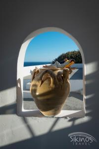 un grand vase assis sur un rebord de fenêtre dans l'établissement Alopronoia Sea Breeze, à Sikinos