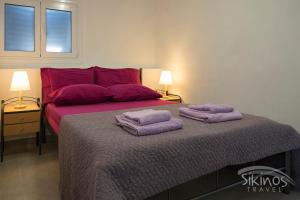1 dormitorio con 1 cama con 2 toallas en Alopronoia Sea Breeze en Síkinos