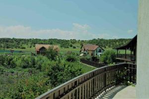 a balcony view of a farm with houses and trees at Casa Andreea. Cheerful 4-bedroom villa in Bod