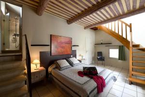 una camera con un letto in una stanza con una scala di Les chambres du Vieux Bistrot a Cabrières-dʼAvignon