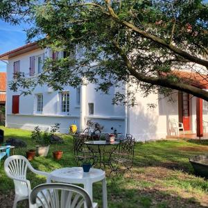 una mesa y sillas frente a una casa blanca en Le Studio Rouge de la Gare, en Vieux-Boucau-les-Bains