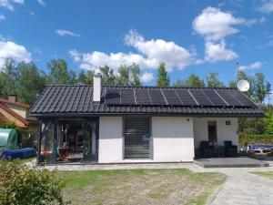 ein Haus mit Sonnenkollektoren auf dem Dach in der Unterkunft Mazury domek całoroczny Pelnik jezioro las in Pelnik + 11 Fotos