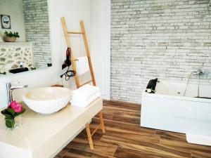 a bathroom with a sink and a bath tub at Restaurante & Hotel Rural El Mirador de Trevejo in Villamiel