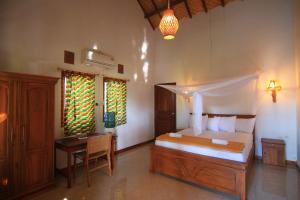 1 dormitorio con 1 cama y escritorio en una habitación en Bidara Cottage, en Labuhanpandan
