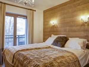 1 dormitorio con 1 cama grande y pared de madera en Appartement La Tania, 5 pièces, 12 personnes - FR-1-513-17 en La Tania