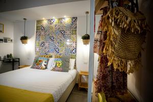 a bedroom with a bed and a wall with tiles at Acquarò Suite Jacuzzi in San Vito lo Capo