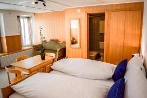 Kleines Zimmer mit 2 Betten und einem Tisch in der Unterkunft First Lodge in Grindelwald