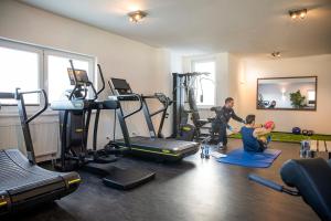 un homme et un garçon dans une salle de sport équipée de machines dans l'établissement TUI BLUE Sylt, à Rantum