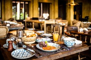 une table en bois avec des assiettes de nourriture dans l'établissement Zannier Hotels Bai San Hô, à Song Cau