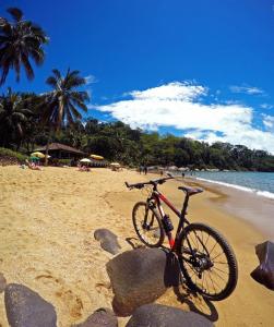 ein Fahrrad parkt am Strand in der Nähe des Wassers in der Unterkunft Casa Colibri - Praias e Cachoeiras in Paraty
