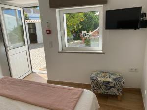 a bedroom with a bed and a window and a tv at Casa Bravo in Querença