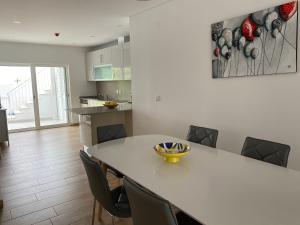 una cucina e una sala da pranzo con tavolo e sedie di Casa Bravo a Querença