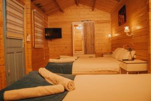 a bedroom with two beds and a tv in a room at Pirlanta Butik Hotel in Çeşme