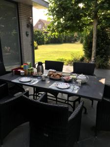 - une table avec une assiette de nourriture sur la terrasse dans l'établissement Hazegewoud, à Arendonk