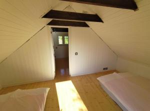 Zimmer im Dachgeschoss mit 2 Betten und einer Tür in der Unterkunft Prangli Valgekivi in Kelnase