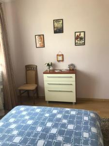 1 dormitorio con 1 cama, vestidor y silla en Apartments in a private house en Ivano-Frankivsk