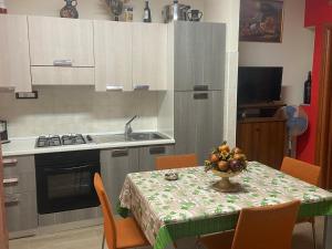 eine Küche mit einem Tisch und einer Obstschale darauf in der Unterkunft La casa di nonna rosetta in Cirò Marina