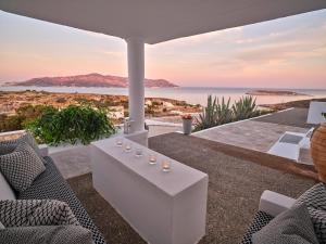 a patio with a table and chairs and the ocean at The Windmill Kimolos in Kimolos