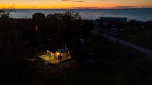 a small house with a light on it at sunset at Prangli Valgekivi in Kelnase +6 photos