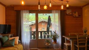 a room with a window with a door and a table at Appartement vue Montblanc 5mn piste1 in Les Houches