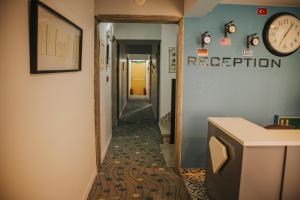 a hallway with a clock on a blue wall at Pirlanta Butik Hotel in Çeşme