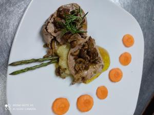 un plato blanco con un trozo de carne y hortalizas en Agriturismo Villa Vea, en Bellosguardo