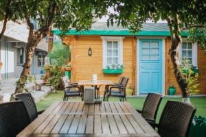 a wooden table and chairs in front of a house at Pirlanta Butik Hotel in Çeşme