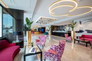 a lobby with pink chairs and a table at Hotel St Martin by OMNIA hotels in Rome