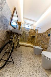 ein Badezimmer mit einem Fahrrad, einem Waschbecken und einem WC in der Unterkunft Affittacamere Nonna Nana in Tirli