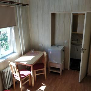 uma pequena cozinha com uma mesa e cadeiras e um frigorífico em Kanepi accommodation One room em Viljandi