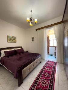ein Schlafzimmer mit einem großen Bett und einem roten Teppich in der Unterkunft White Villa in Berat