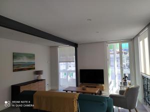 salon z telewizorem z płaskim ekranem i kanapą w obiekcie Apartamentos Pontedeume Riadoeume w mieście Puentedeume