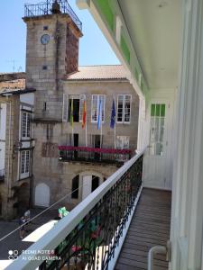 balkon budynku z wieżą zegarową w obiekcie Apartamentos Pontedeume Riadoeume w mieście Puentedeume