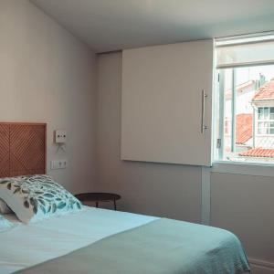 sypialnia z łóżkiem i dużym oknem w obiekcie Apartamentos Pontedeume Riadoeume w mieście Puentedeume
