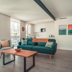 salon z zieloną kanapą i stołem w obiekcie Apartamentos Pontedeume Riadoeume w mieście Puentedeume