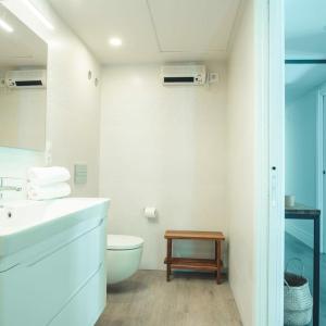 Baño blanco con lavabo y aseo en Apartamentos Pontedeume Riadoeume, en Puentedeume