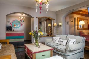sala de estar con sofá y mesa con flores en La Justina Hostel en San Carlos de Bariloche