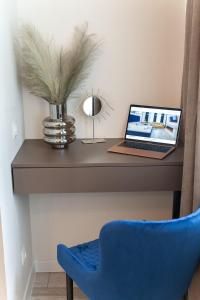 escritorio con ordenador portátil y silla azul en Avangard Franko* Art Apartment, en Leópolis