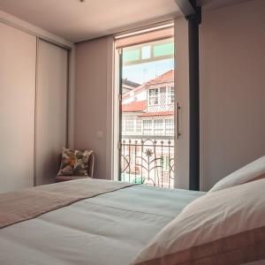sypialnia z łóżkiem i dużym oknem w obiekcie Apartamentos Pontedeume Riadoeume w mieście Puentedeume