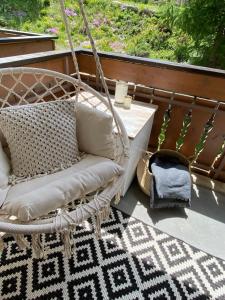 een schommelstoel op een veranda met een tapijt bij Sonnmatten Boutique Hotel & Apartments Zermatt in Zermatt