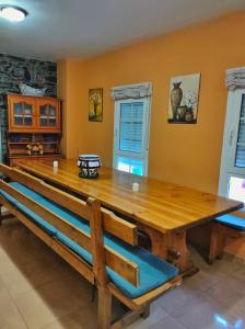 een eetkamer met een grote houten tafel en banken bij A Casiña do Patio in Quiroga