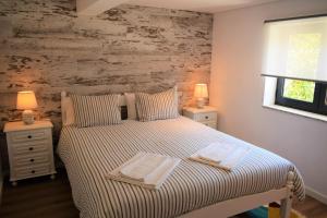 a bedroom with a bed with two towels on it at Casa da Romeira in Ponte de Lima