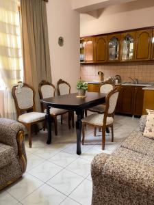 een eetkamer met een tafel en stoelen en een keuken bij White Villa in Berat