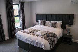 a bedroom with a large bed with two towels on it at Anelli Hotel in Southport